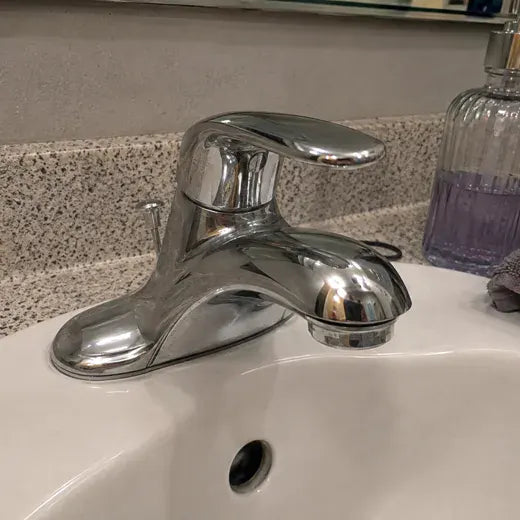 Shiny chrome bathroom faucet after cleaning