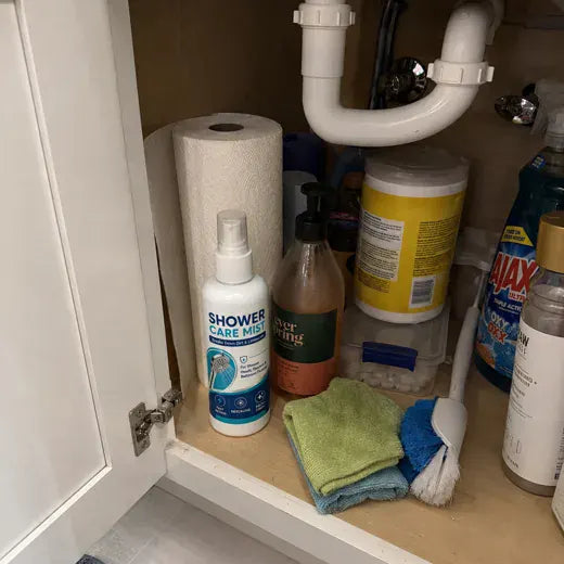 One Shower Care Mist bottle among household cleaners