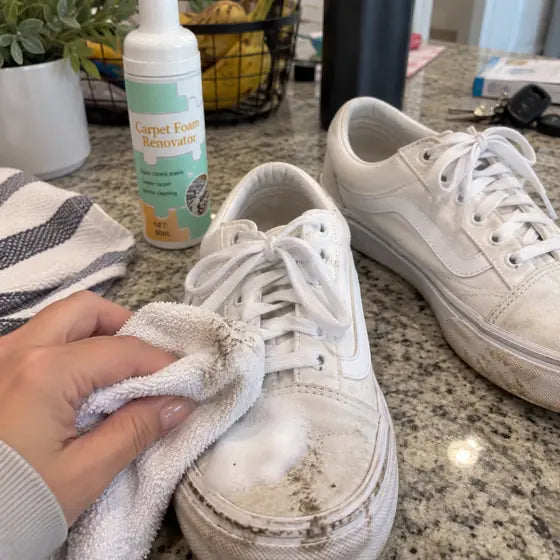 White canvas shoes being cleaned with foam and towel